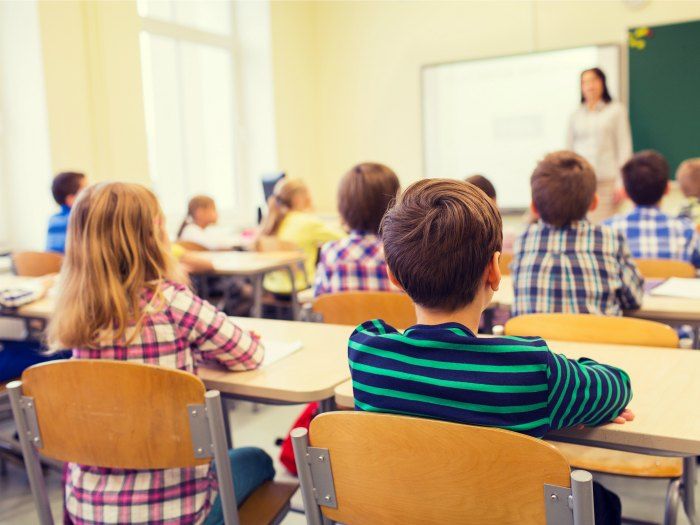 group of school kids and teacher in classroom