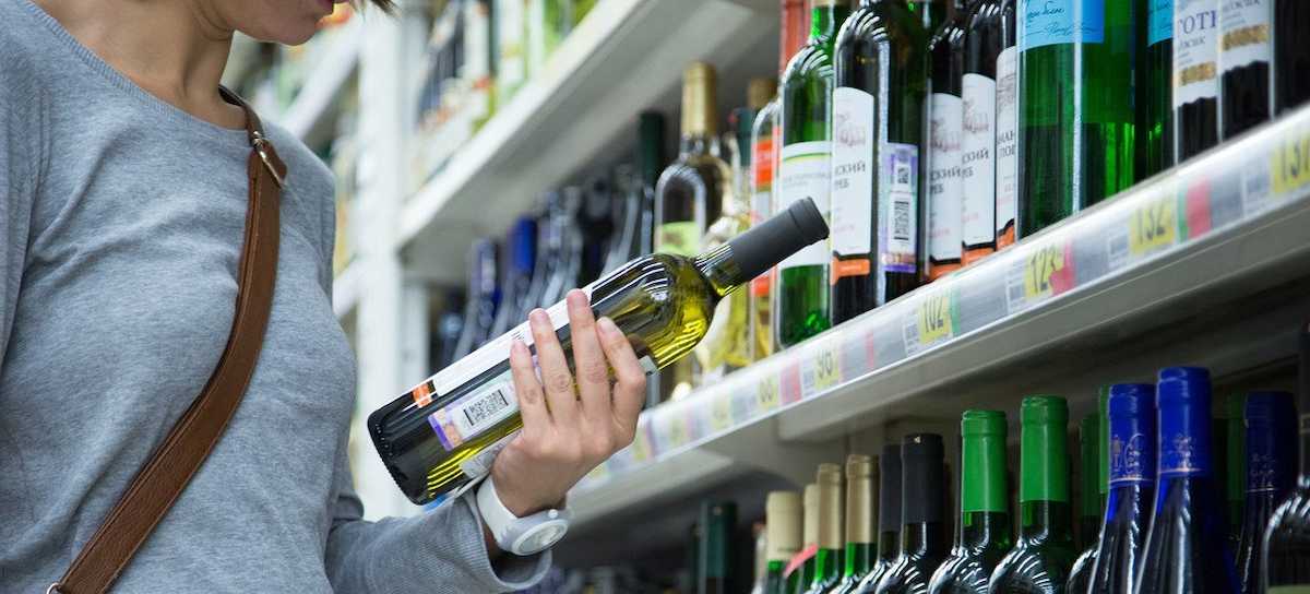 La región de la OMS llamada Europa, abarca a los países europeos y centroasiáticos. Una mujer observa una botella de vino en un supermercado de Moscú. | Foto: OMS/Sergey Volkov