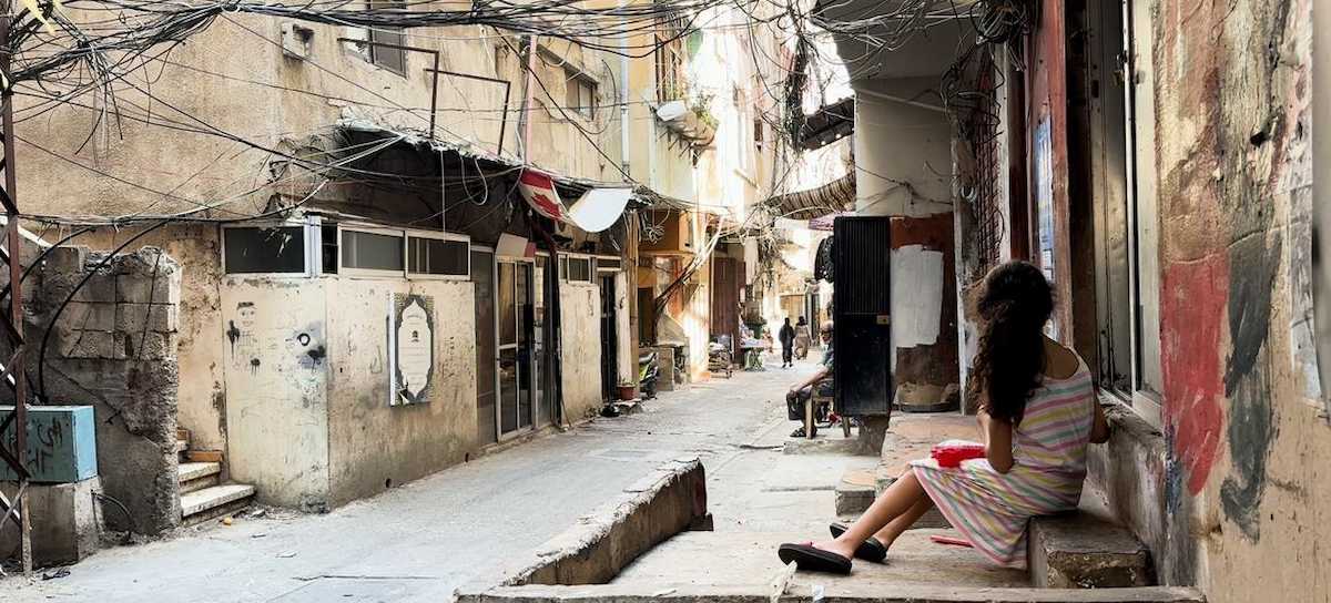 Una niña sentada frente a su casa en el campo de palestinos refugiados de Al-Biddawi, en Líbano. donde la vida cotidiana pasa lenta. | Foto: ONU / Ezzat El-Ferri