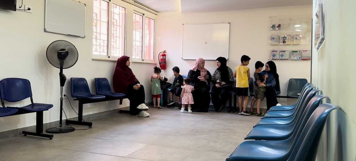 Mujeres con sus hijos en la sala de espera del centro de salud de UNRWA del campo de refugiados palestinos Al-Baddawi, Líbano. | Foto: ONU / Ezzat El-Ferri