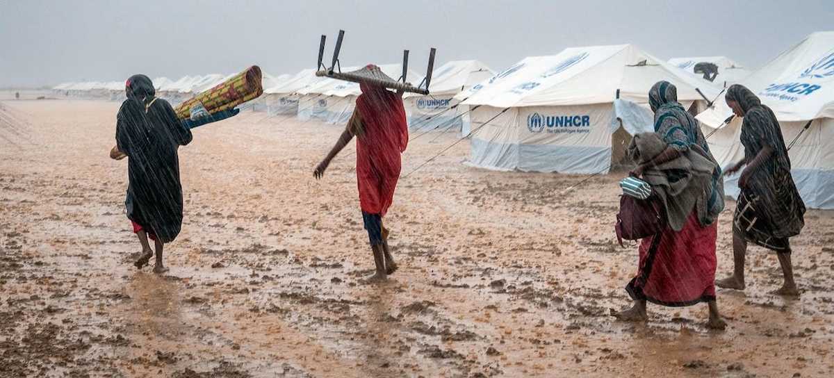 Mujeres desplazadas tratan de poner a salvo sus pertenencias durante la temporada de lluvias en Kassala, Sudán. | Foto:  ACNUR/Ayem Alfadil