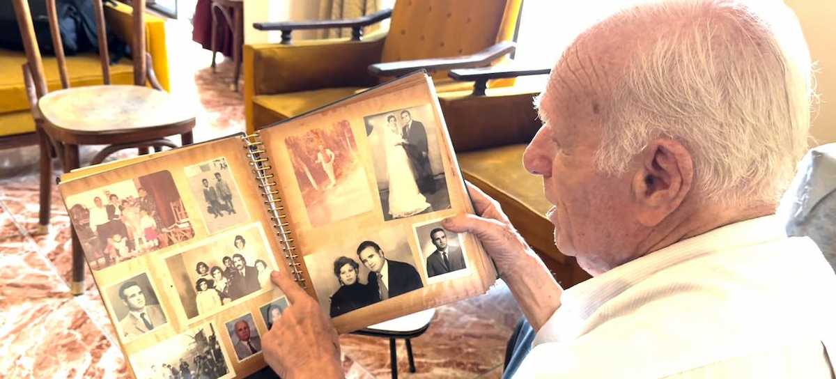 Mahmoud Al-Said repasa algunas de las fotos de su familia reunidas a lo largo de 76 años de refugio en Líbano. | Foto: ONU/Ezzat El-Ferri