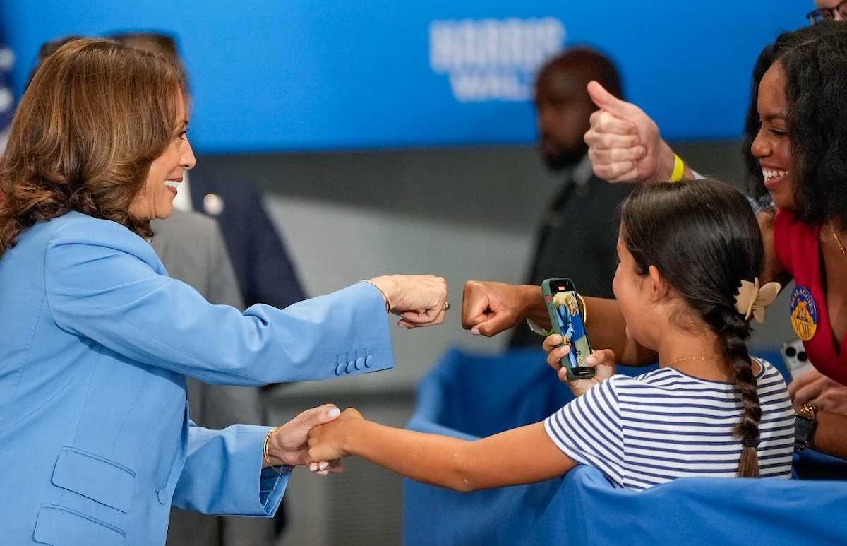 Kamala Harris saluda a unas jóvenes durante la convención demócrata