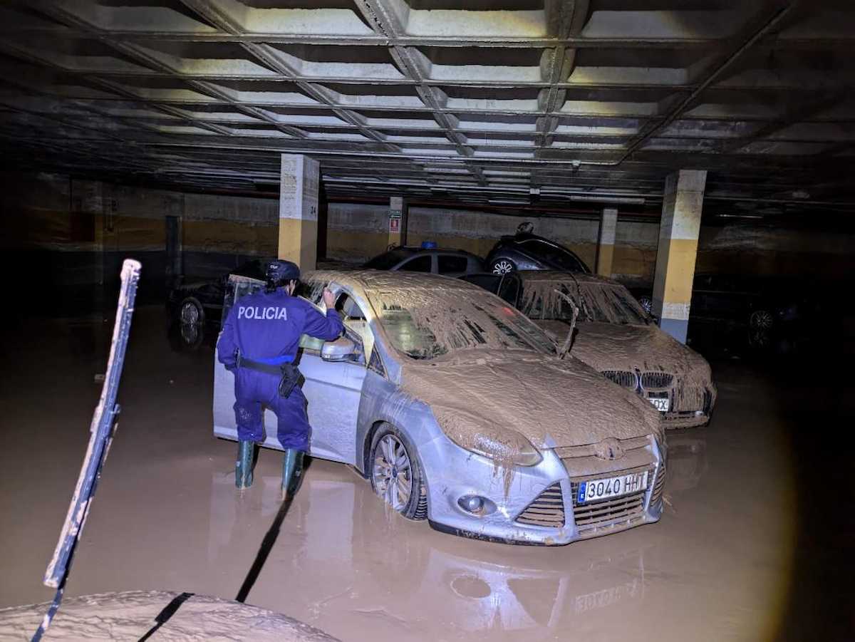 Efectivos de la Policía Nacional inspecciones vehículos en un garaje inundado en Paiporta, uno de los municipios incluidos en los 25.000 kilómetros de zonas inundables. | Foto: CNP