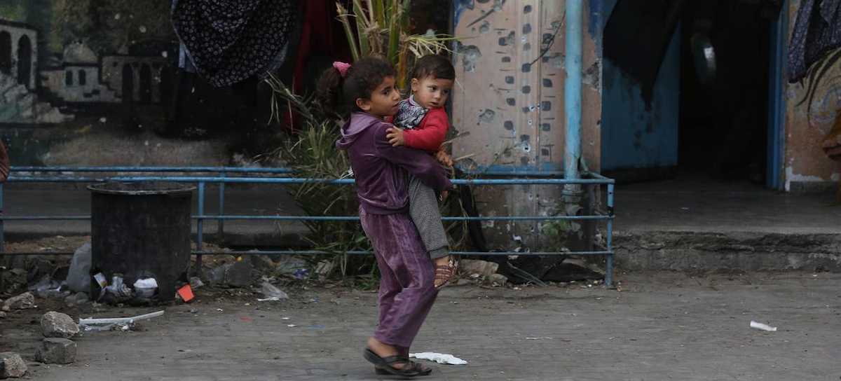 Una niña carga a un bebé en las devastadas calles de Gaza mientras se habla de anexión. | Foto: UNRWA 