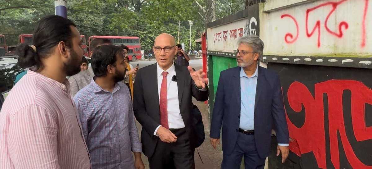 El Alto Comisionado para los Derechos Humanos, Volker Türk, con unos estudiantes que le muestran las pintadas realizadas durante la protesta de julio cerca de la Universidad de Dhaka, Bangladesh. | Foto: UNOHCHR/Anthony Headley