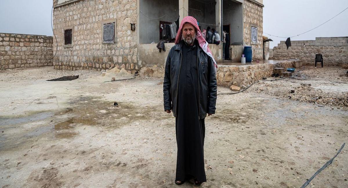 Un hombre frente a la casa rehabilitada de su familia en la zona rural del sur de Alepo (Siria). | Foto: UNHCR/Hameed Maarouf