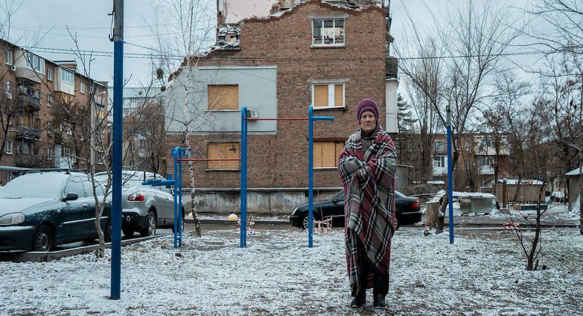 Una mujer delante de su casa dañada por drones y bombas en Kharkiv, Ucrania. | Foto: UNOCHA/Yurii Veres