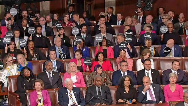 Congresistas demócratas en el Congreso sostienen carteles en que acusan a Trump de mentir durante su discurso