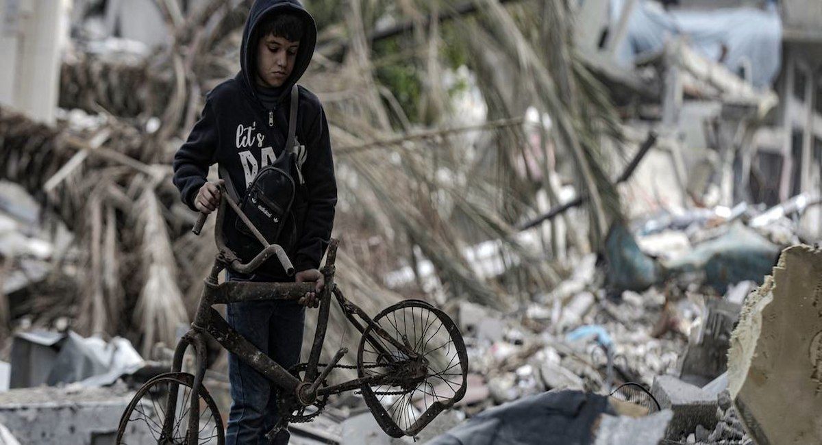 Un niño recupera una bicicleta rota en la zona de Al-Touam, en el norte de la Franja de Gaza. | Foto:  UNICEF/Mohammed Nateel