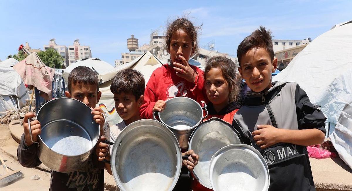 Niños en Gaza esperando a que les llenen cazuelas vacías de comida. | Foto:  ONU