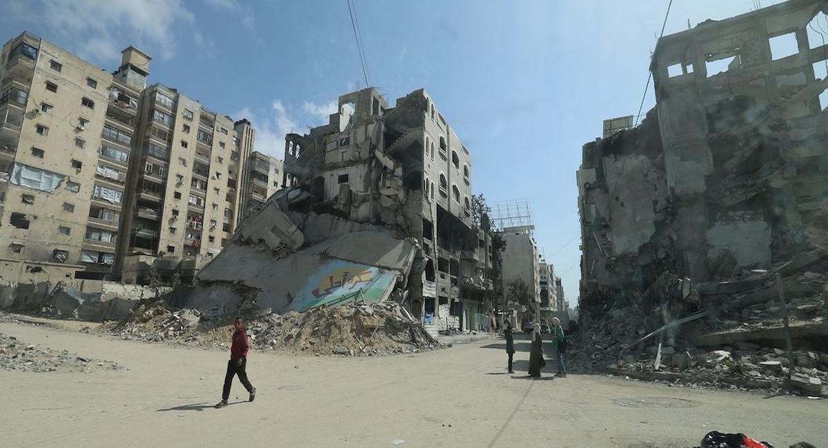Personas recorren las calles entre escombros y edificios bombardeados en Gaza. | Foto: UNFPA/Yasmeen Sous