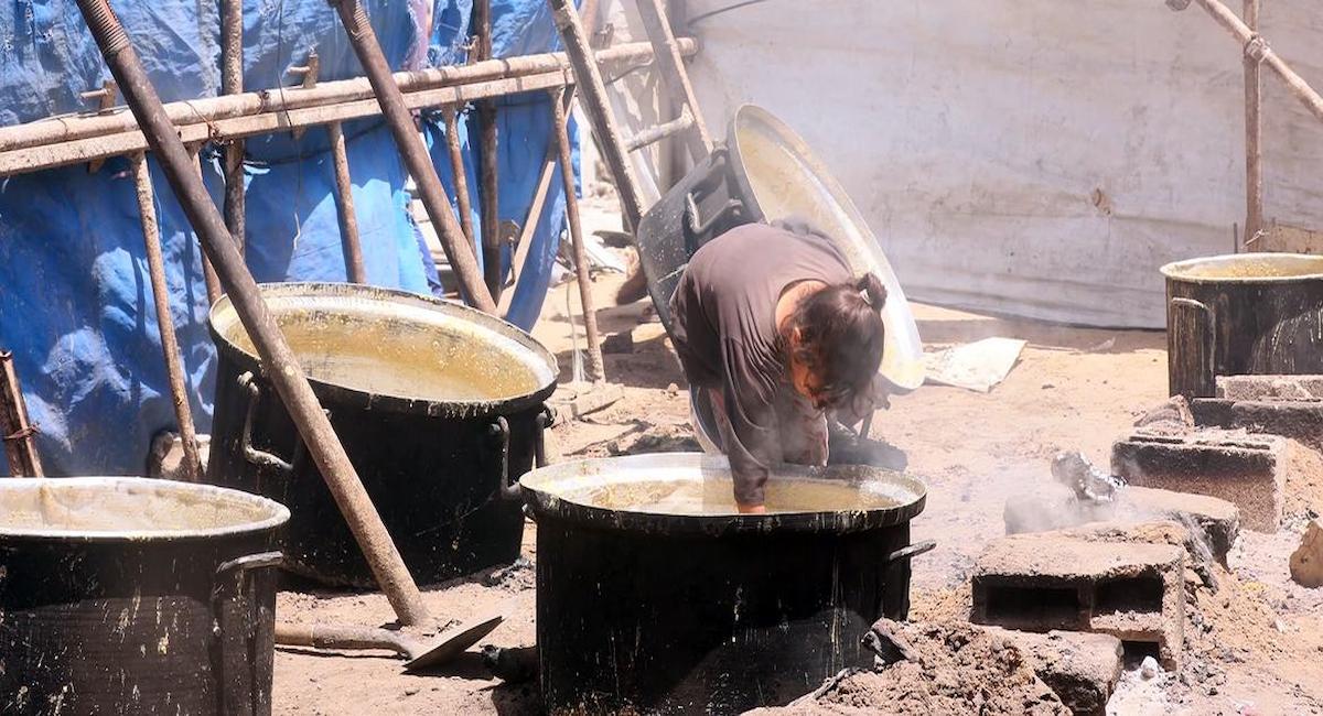 Mientras los ataques de Israel no cesan, una niña de Gaza intenta recoger los restos de comida que quedan en la olla. | Foto: ONU