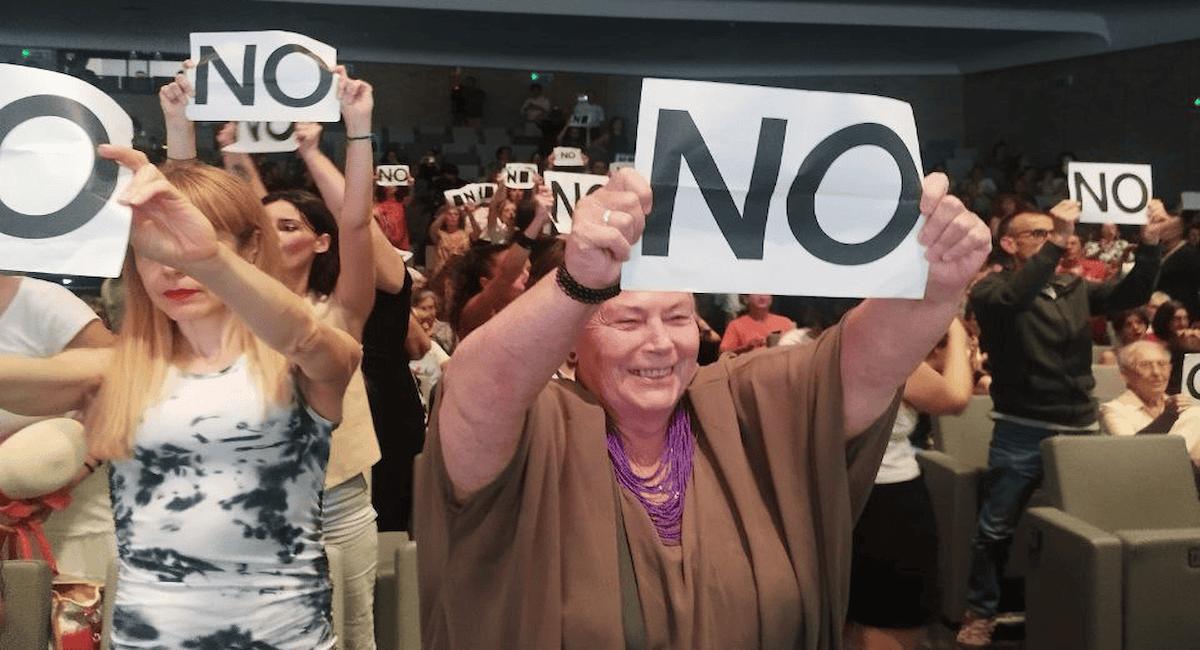 Tras las palabras de las religiosas, el auditorio se levantó portando carteles donde se leía “No” (simbolizando que no aceptaban el perdón). | Foto: Ecologistas en Acción