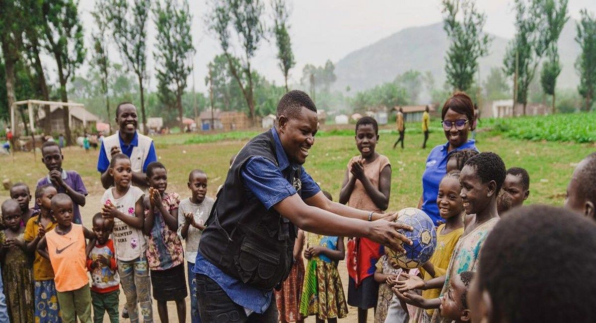 Un trabajador social, Apoyado por UNICEF, juega con niños en un espacio seguro apoyado por UNICEF en Bweremana, en la provincia de Kivu Norte, RD del Congo. | Foto: UNICEF/UNI786600/Jospin Benekire