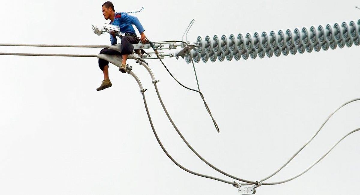 Un trabajador instala un cable de electricidad en Filipinas. | Foto: OIT/Bobot Go