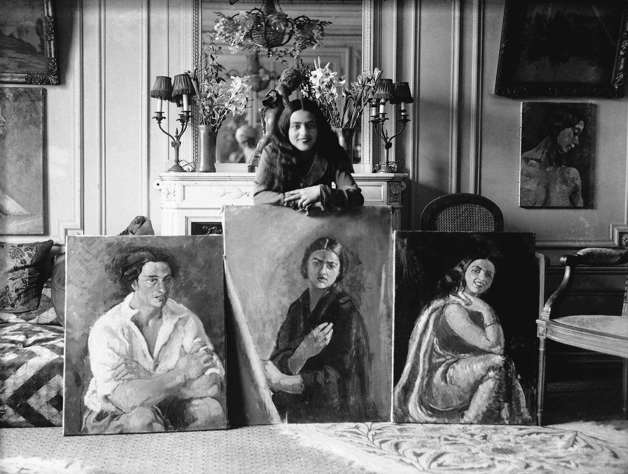 Amrita Sher Gil con tres de sus obras