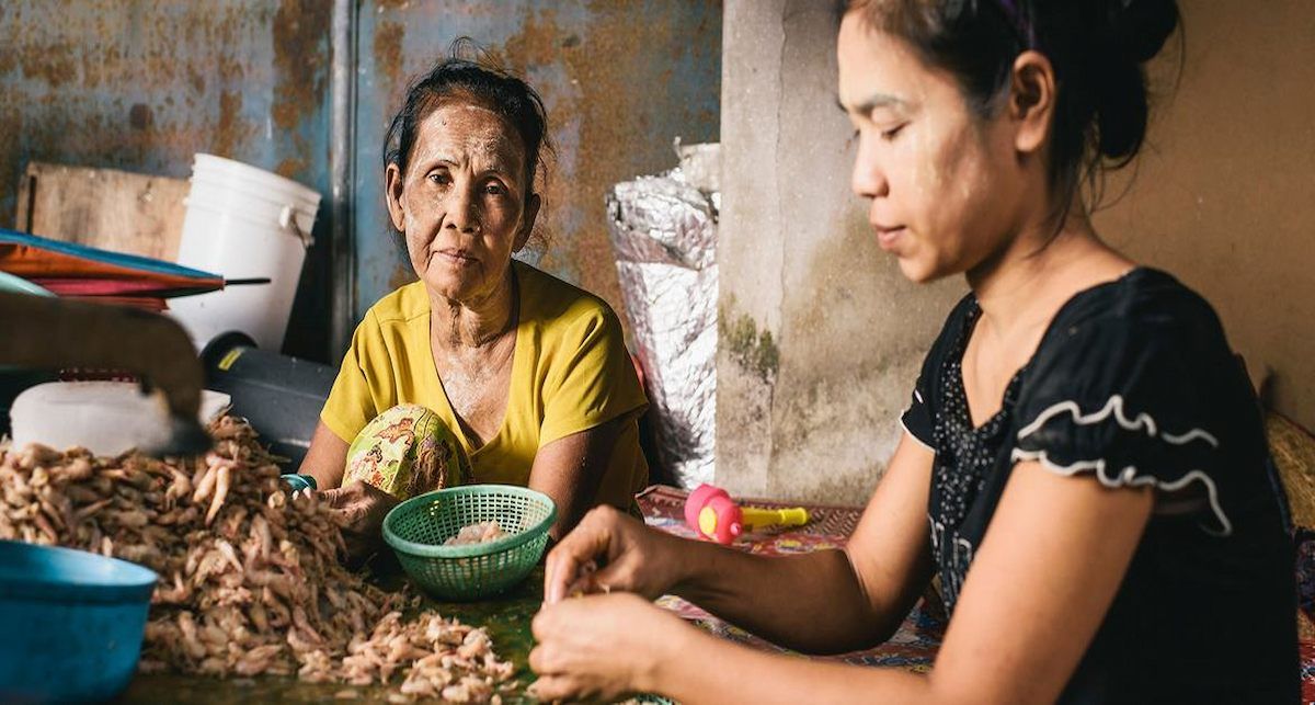 Una mujer de 76 años de Myanmar, que viajó sola a Tailandia, trabaja pelando camarones en Rangong. | Foto: OIM/Benjamin Suomela