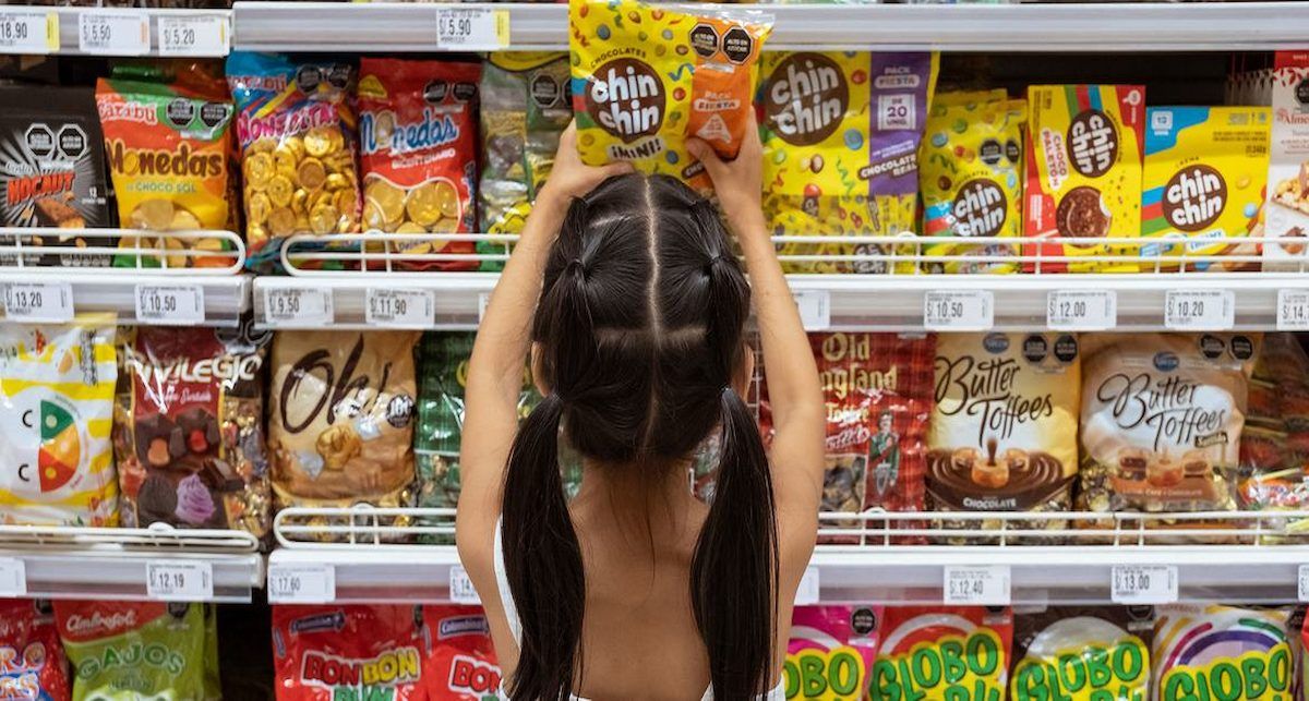 La publicidad dirigida a los niños también juega un papel determinante. Una niña elige una golosina en un supermercado de Lima, Perú. | Foto:  UNICEF/Florence Goupil
