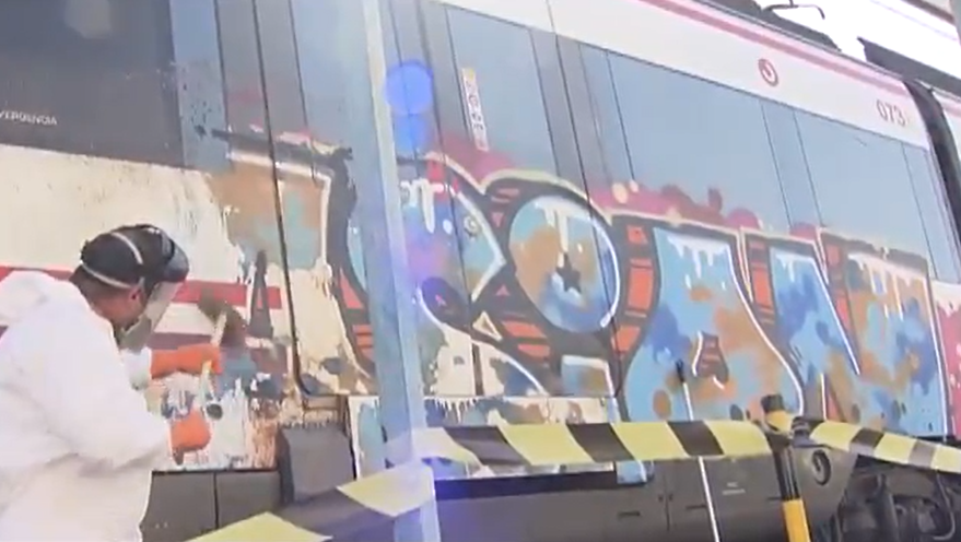 Un operario limpia un grafiti en un tren de Madrid.