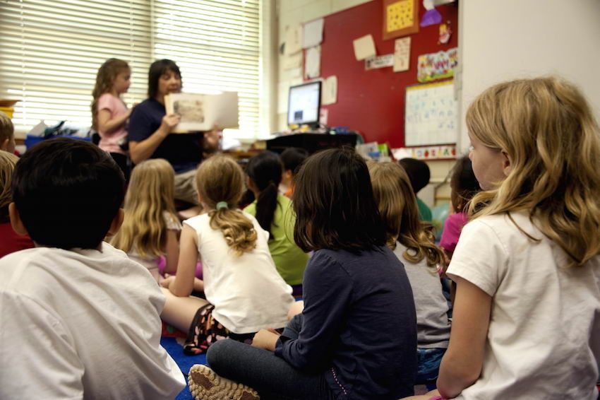 Typical classroom scene where an audience of school children were seated on the floor