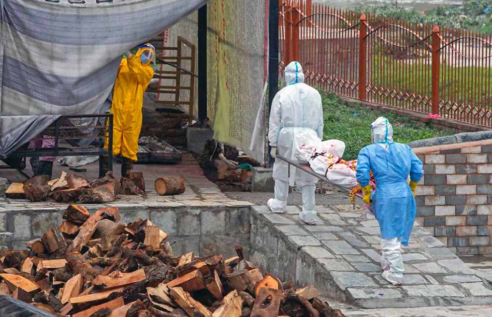 Dos operarios llevan un cuerpo para incinerar en un crematorio de Nepal.