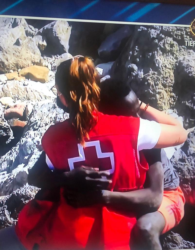 Una trabajadora de Cruz Roja atiende a uno de los inmigrantes llegados a nado