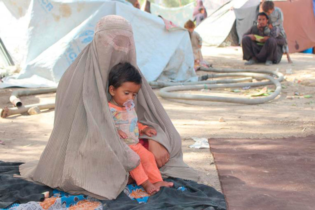 Mujer afgana con su hijo en un campo de refugiados