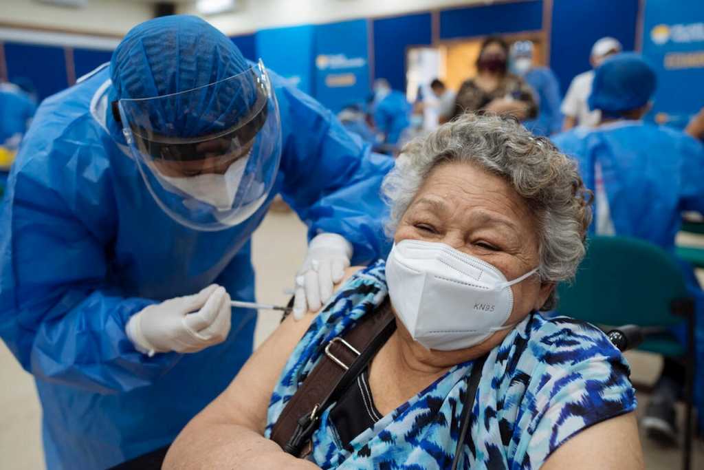 Una enfermera inocula la vacuna a una mujer.