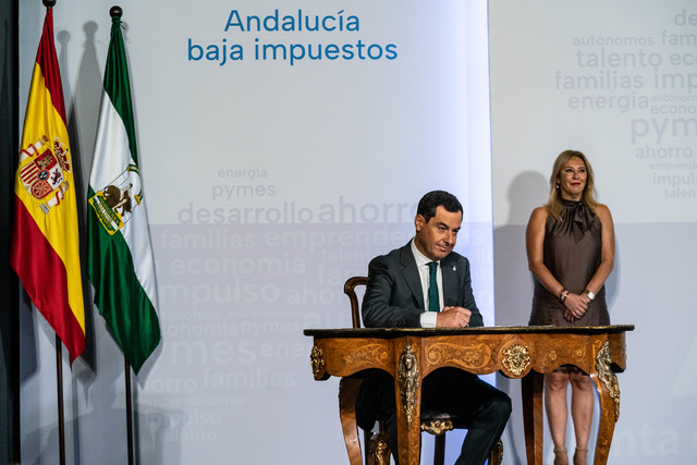Moreno Bonilla, en primer plano, firma el decreto de la bajada de impuestos para las rentas altas. Al fondo, la titular de Hacienda, Carolina España.