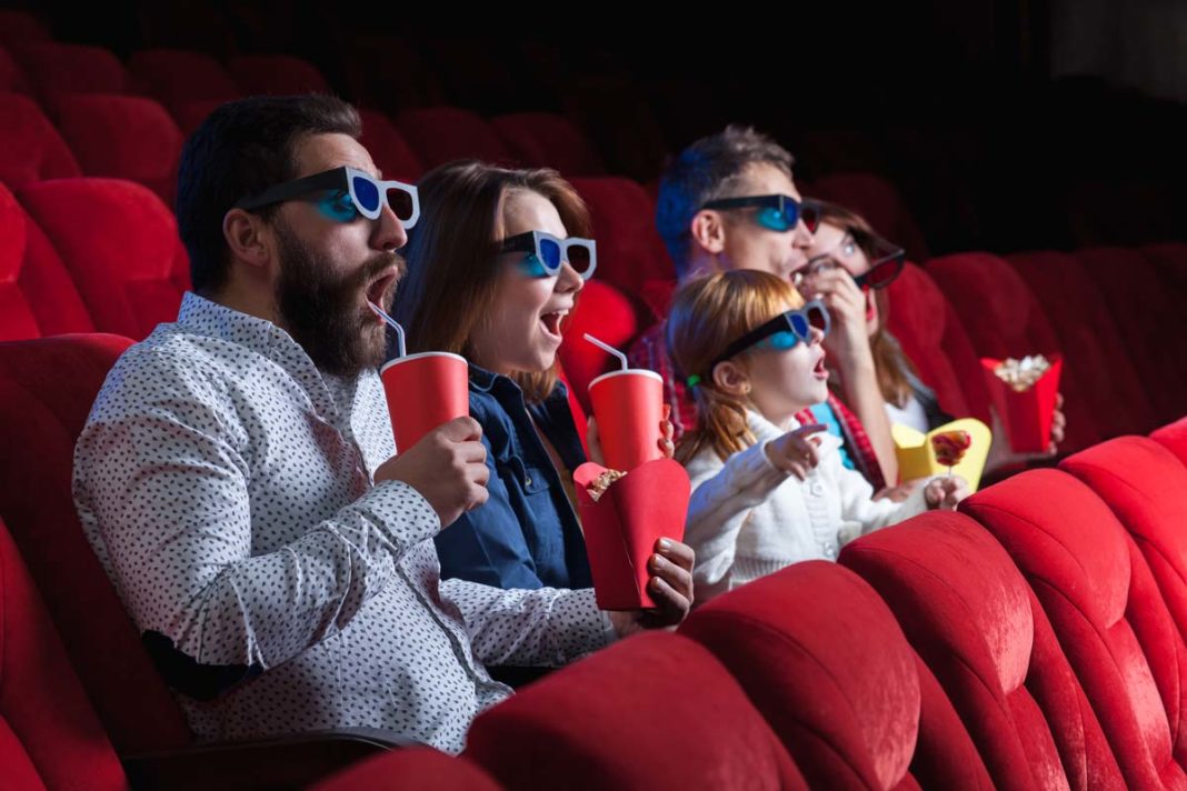 Gente disfrutando viendo una pelicula en el cine