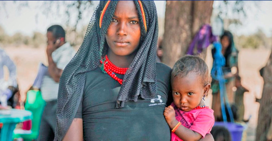 Martha Tadesse Temira en la foto con su hija Zahara, de 12 meses, frente al equipo móvil de salud y nutrición del sitio de Eltomale en Chifra, Afar, Etiopía OMS parto